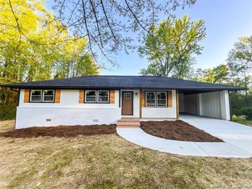 Charming renovated home with white brick, black trim, natural wood shutters, and a covered carport at 7817 Mattie Mccoy Ln, Winston, GA 30187