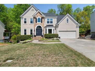Beautiful two-story home with stone accents, a well-manicured lawn, and an attached two-car garage at 1165 Evergreen Oak Way, Dacula, GA 30019