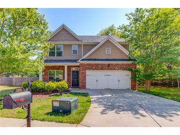 Charming two-story home featuring a manicured lawn, brick accents, and a convenient two-car garage at 1691 Scenic Pines Dr, Lawrenceville, GA 30044