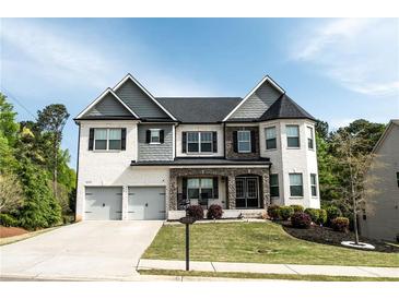 Beautiful two-story home featuring a white brick exterior, well-manicured lawn, and a two-car garage at 4685 Columbia St, Cumming, GA 30040