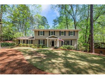 Charming home featuring a large front yard, traditional architecture, and mature trees at 965 River Overlook Ct, Sandy Springs, GA 30328