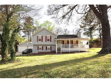 Charming home with a covered porch, red shutters, gray siding, and a detached two-car garage at 24 Lady Savannah Dr, Dallas, GA 30157