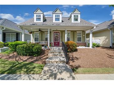 Charming one-story home featuring a cozy porch with colorful front door and well-manicured front yard at 4510 Flowering Br, Powder Springs, GA 30127