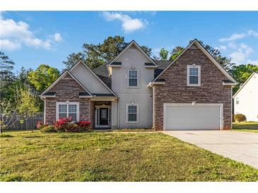 Charming two-story home featuring a stone and siding facade, a well-manicured lawn, and an attached two-car garage at 113 Highgrove Pl, Mcdonough, GA 30253