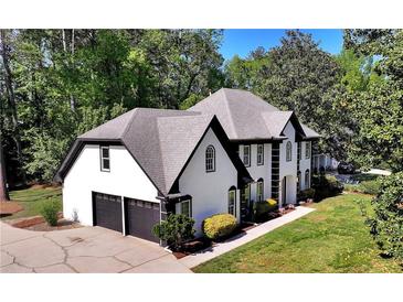 Stately two-story home with a well-manicured lawn and a two-car garage, framed by lush trees at 2648 Kenwood Dr, Duluth, GA 30096