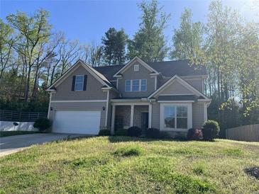 Charming two-story home featuring a two-car garage, neutral siding, and well-manicured lawn at 231 Creek View Pl, Canton, GA 30114