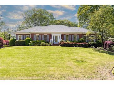 Charming brick home with a well-manicured lawn and landscaped front yard at 4579 Blakedale Ne Cir, Roswell, GA 30075
