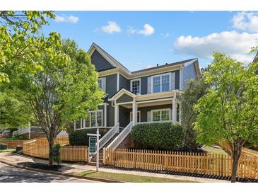 Charming home with a well-manicured lawn and inviting front porch, surrounded by mature trees and a picket fence at 1605 Gilstrap Nw Ln, Atlanta, GA 30318