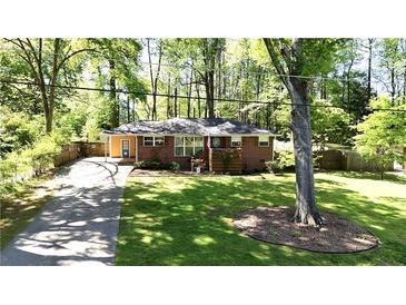 Charming brick home featuring a lush lawn, mature trees, and a long driveway at 4257 Webb Rd, Tucker, GA 30084