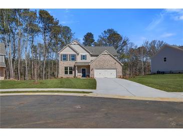 Charming two-story brick home with a well-manicured lawn and attached two-car garage at 128 Felicity Pike, Locust Grove, GA 30248