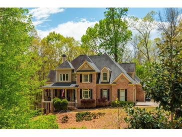 Beautiful brick home with mature trees and manicured landscaping providing excellent curb appeal at 107 Estates At The Lake Dr, Canton, GA 30114