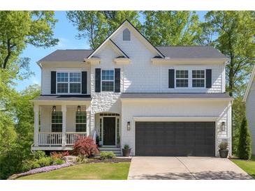 Charming two-story home with a covered front porch and a two-car garage in a leafy neighborhood at 4965 Skyland Pkwy, Cumming, GA 30028