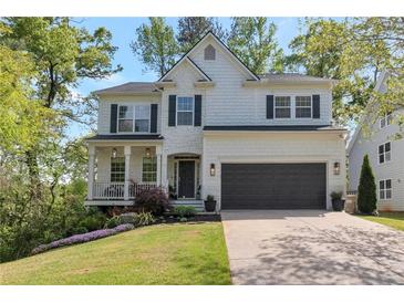 Charming two-story home featuring black shutters, a two-car garage, and a beautifully landscaped front yard at 4965 Skyland Pkwy, Cumming, GA 30028
