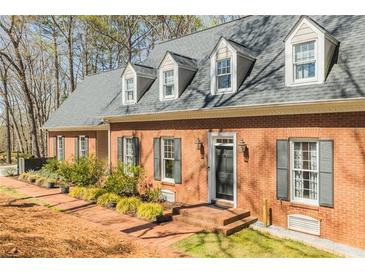 Charming brick home featuring dormer windows and black shutters, creating a classic and inviting facade at 1250 Northcliff Trce, Roswell, GA 30076