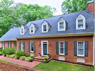 Beautiful brick home with dormer windows, black shutters and a landscaped front yard with a brick walkway at 1250 Northcliff Trce, Roswell, GA 30076
