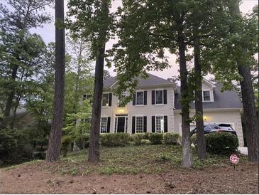 Charming two-story home with black shutters and a well-maintained lawn, partially obstructed by trees at 180 Shyrewood Dr, Lawrenceville, GA 30043