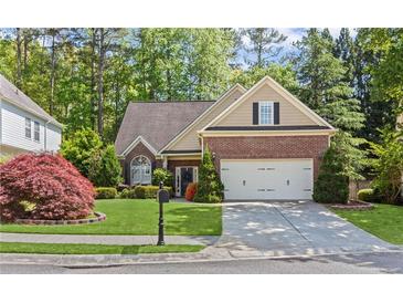 Charming brick and tan home with a well-manicured lawn, complemented by mature trees and lovely landscaping at 2106 Berryhill Se Cir, Smyrna, GA 30082