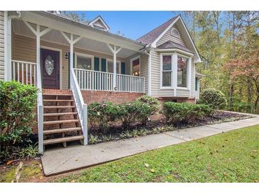 Charming home featuring a covered front porch, manicured landscaping, and brick accents at 469 Kimberly Ct, Mcdonough, GA 30252