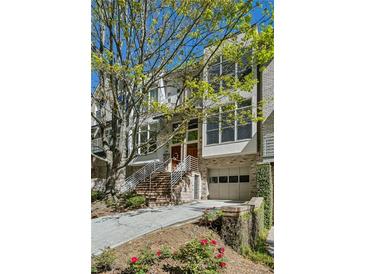 Striking townhouse with a brick facade, multiple windows, brick steps and a garage for convenient parking at 1294 Fernwood Ne Cir, Brookhaven, GA 30319