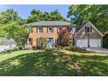 Charming two-story brick home with well-manicured lawn and a two-car garage at 3051 Deanna Way, Lawrenceville, GA 30044