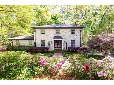 Charming brick home featuring a manicured front yard with lush landscaping and a symmetrical facade at 4175 Valley Trail Se Dr, Atlanta, GA 30339
