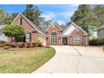 Charming brick home featuring a well-manicured front yard with mature trees and an inviting driveway at 2602 White Aster Ln, Dacula, GA 30019