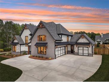 Stunning two-story home with a brick and white exterior, gray roof, and a spacious driveway at 1095 Lanier Pl, Cumming, GA 30041