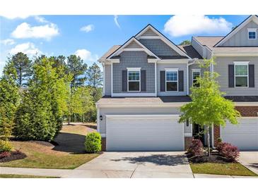 Two-story home with gray siding, two-car garage, and landscaped front yard at 136 Grant Dr, Canton, GA 30114