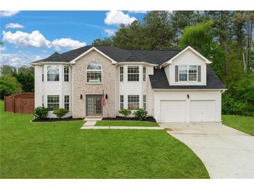 Charming two-story home featuring a lush green lawn, brick facade, and attached two-car garage at 160 Fieldstone Dr, Powder Springs, GA 30127