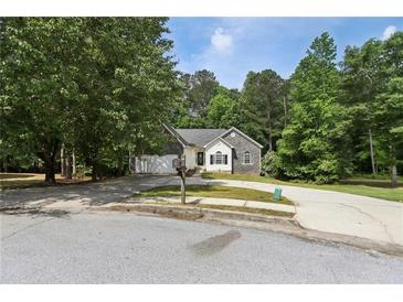 Charming one-story home with stone accents, well-maintained lawn, and a spacious driveway at 1945 Grayson Oaks Ct, Lawrenceville, GA 30045
