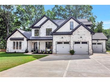Striking white brick home featuring black trim, three-car garage, and well-manicured lawn at 801 Braselton Hwy, Lawrenceville, GA 30043