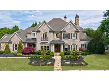 Stunning two-story brick home with meticulously landscaped front yard and charming architectural details at 3250 Twisted Branches Ln, Marietta, GA 30068