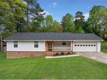 Charming single-story home features a well-manicured lawn, brick accents, and a welcoming front porch at 3451 Birchwood Trl, Snellville, GA 30078