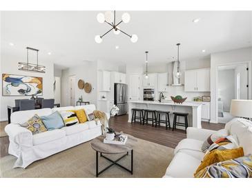 Bright, open-concept living space flows into a modern kitchen with a large island and stainless steel appliances at 3698 Annsbury Ct, Lilburn, GA 30047