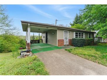Ranch style home with covered porch, driveway, and mature trees at 5335 Old Floyd Sw Rd, Mableton, GA 30126