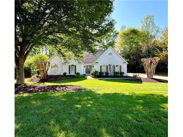 Charming one-story home with a well-manicured lawn and a beautiful, mature shade tree in the front yard at 7375 Cavaletti Cir, Cumming, GA 30040