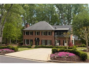 Stately brick home with manicured landscaping, mature trees, and a circular driveway at 5790 Heards Forest Dr, Atlanta, GA 30328