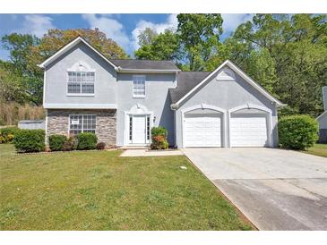 Charming two-story home with a two-car garage and manicured lawn at 1444 Bridgewater Br, Stone Mountain, GA 30088
