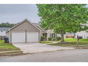 Charming one-story home featuring a two-car garage, well-maintained lawn, and mature tree at 4719 Score Ct, Snellville, GA 30039