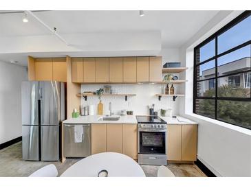 Bright kitchen featuring stainless steel appliances, modern cabinets, and a subway tile backsplash at 1805 Harvard Ave # 207, College Park, GA 30337