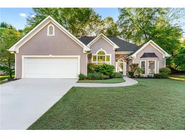 Charming home featuring well-manicured lawn, stone accents, and a two-car garage at 705 Branch Tree Way, Lawrenceville, GA 30043