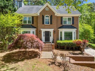 Charming two-story brick home with a manicured front yard and mature landscaping at 401 Briardale Court, Woodstock, GA 30189