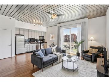 Bright living room featuring modern furnishings and a walk-out balcony with city views at 620 Glen Iris Ne Dr # 410, Atlanta, GA 30308