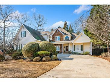 Charming home featuring a stone facade, well-manicured landscaping, and a spacious driveway at 7420 Colony Ct, Cumming, GA 30041
