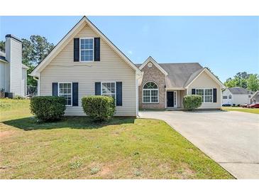 Traditional two-story home featuring vinyl siding, black shutters, mature landscaping, and a concrete driveway at 811 Betsy Ross Trl, Hampton, GA 30228