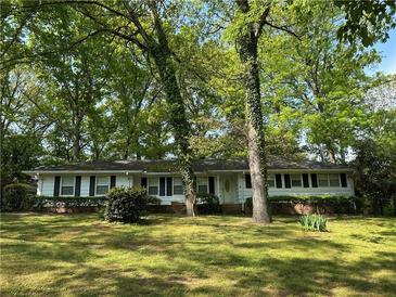 Charming single-story home with lush green lawn and mature trees providing ample shade at 2963 Williams Pl, Snellville, GA 30078