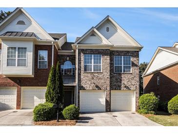 Charming brick townhome with a well-manicured lawn and attached two-car garage at 3499 Henderson Reserve, Atlanta, GA 30341