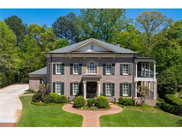 Stunning brick home featuring lush landscaping, a balanced facade, and an inviting entrance at 385 Laurel Chase Ct, Atlanta, GA 30327
