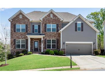 Beautiful two-story home featuring brick and gray siding, a manicured lawn and a two-car garage at 3950 Grandview Manor Dr, Cumming, GA 30028