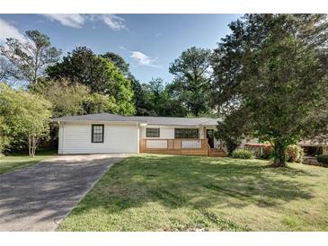 Charming single story house with a large front yard and a freshly painted white brick facade with black trim at 3207 Bobbie Ln, Decatur, GA 30032